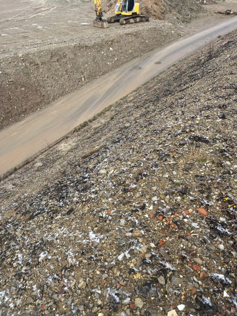 Polymer-treated slope of mixed rubble beside a haul road at an extraction site