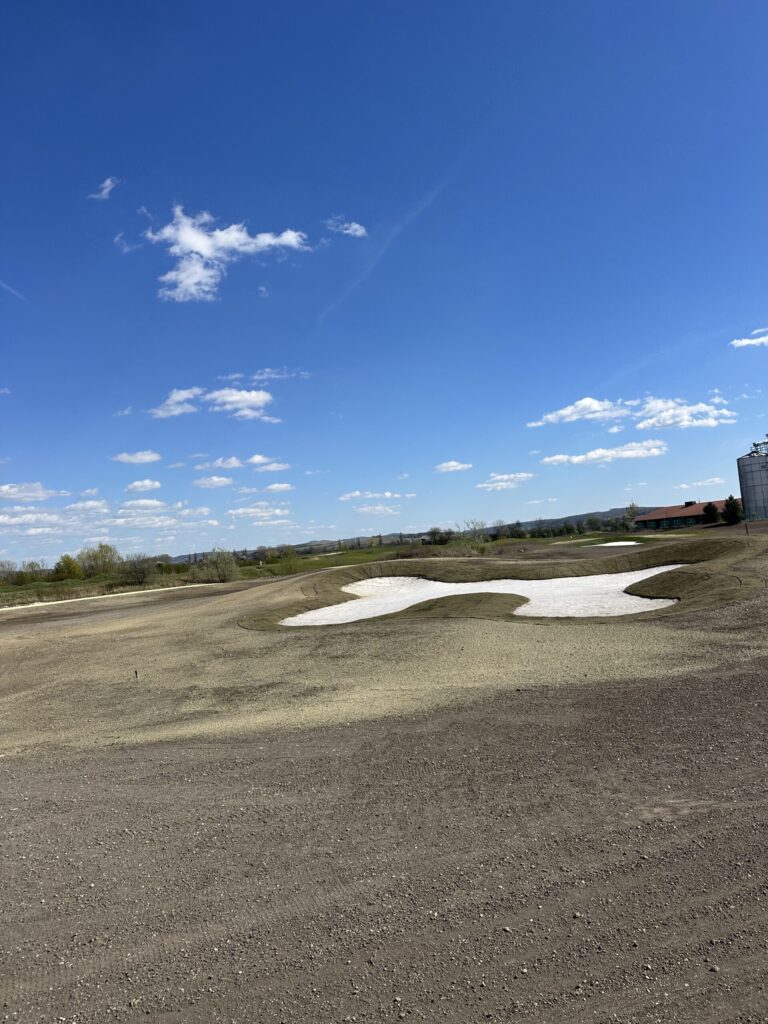 Golf hole under construction with a shaped sand bunker