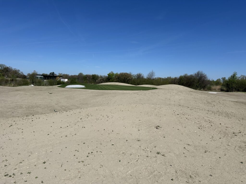 Newly built golf green and bunkers with a sand fairway in the foreground